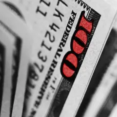 Zbliżenie na banknot 100 dolarów z czerwonym oznaczeniem liczby 100.
