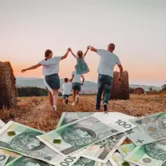 Rodzina biegnie przez pole z sianem, na pierwszym planie polskie banknoty 100 zł.